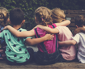 Kids sitting with arms around each other